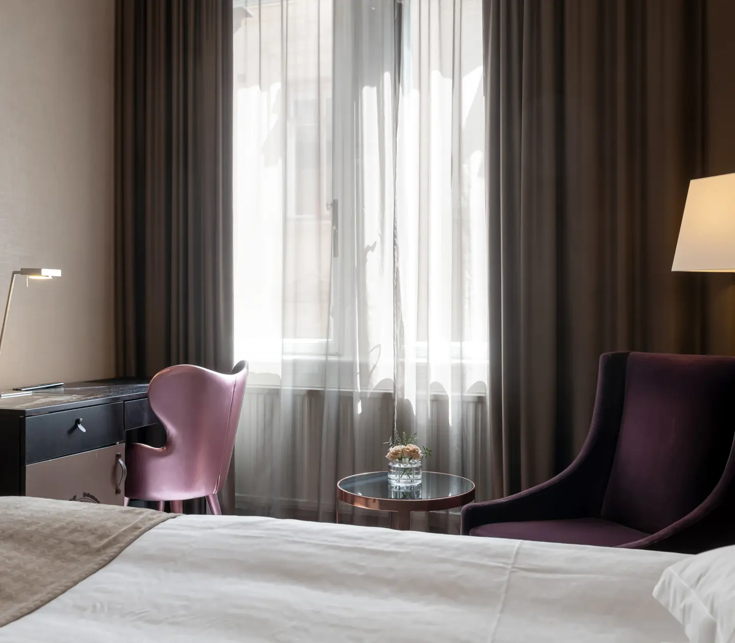Hotel room with armchair, desk and window
