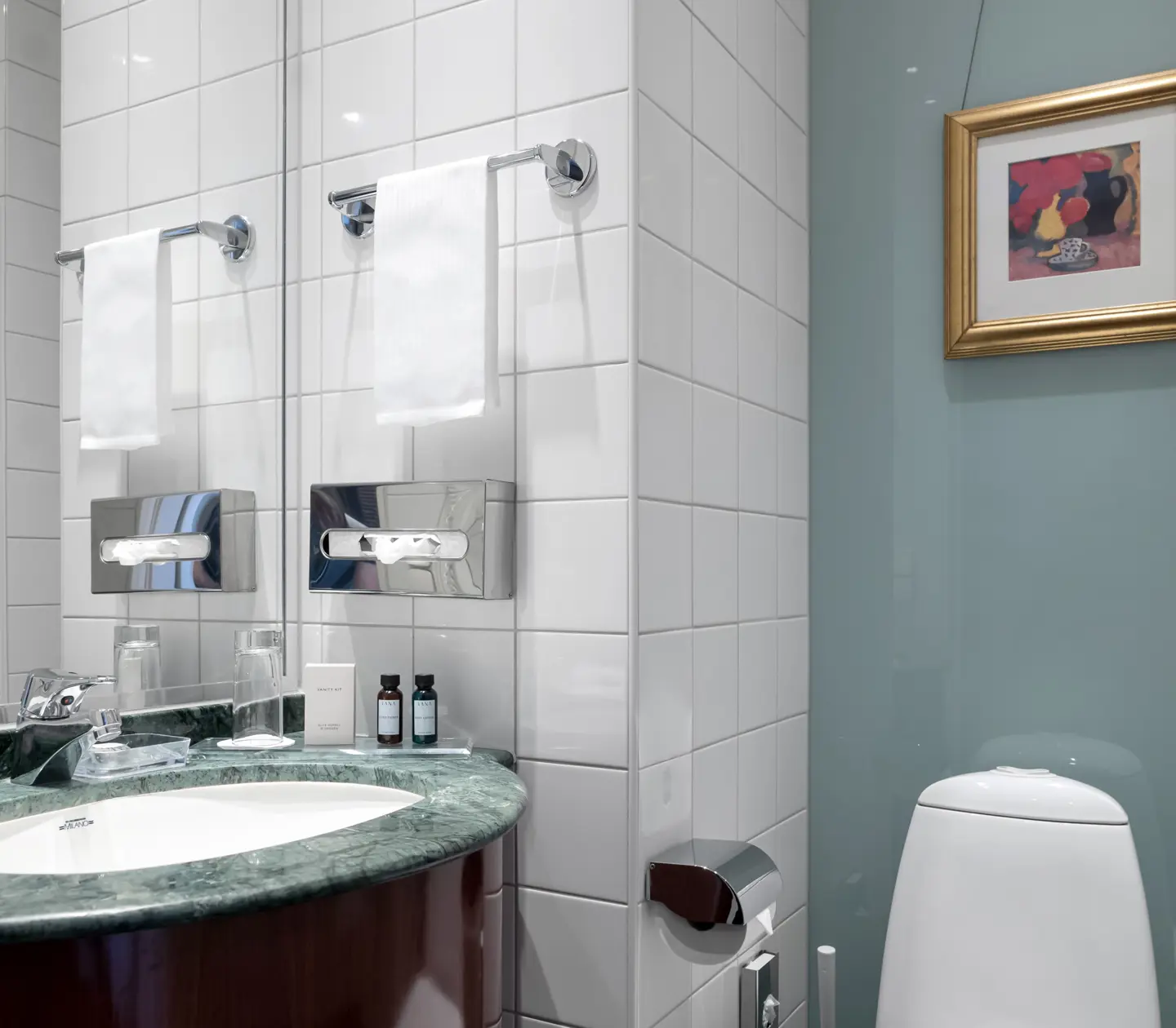 Bright bathroom with toilet, sink and mirror