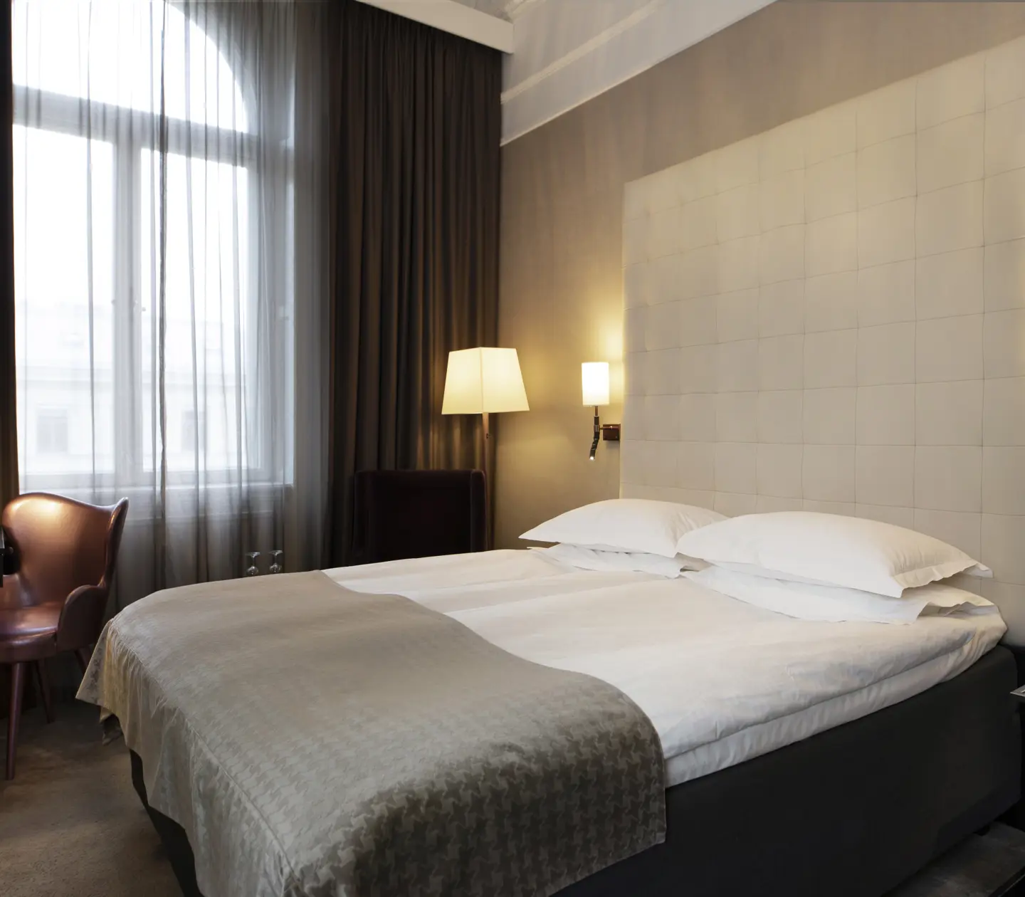 Hotel room with bed, large headboard and desk