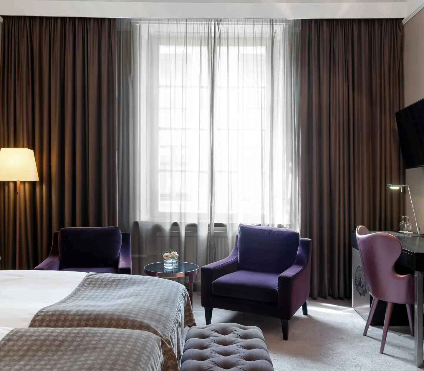 Hotel room with bed, armchairs and desk