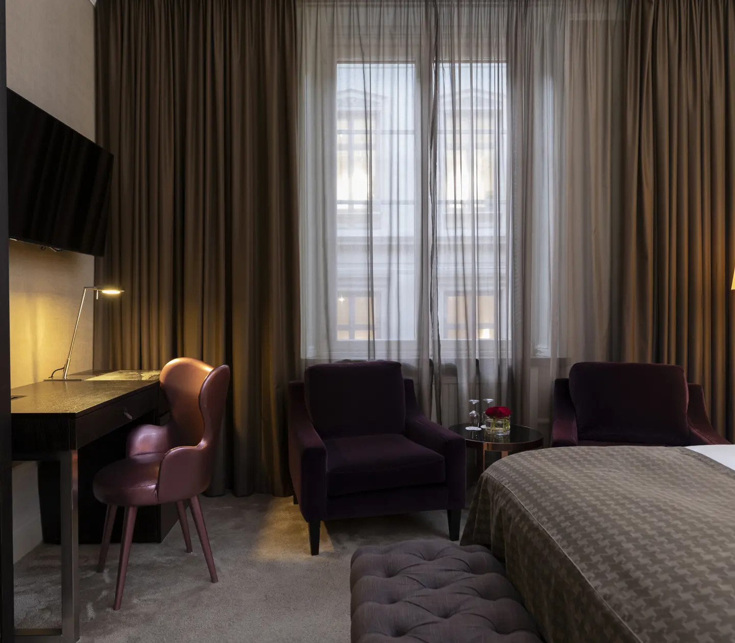 Hotel room with armchairs, desk and television