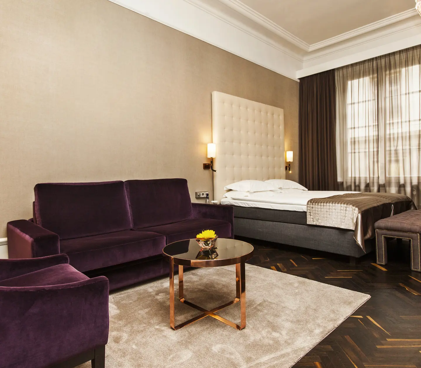 Hotel room with bed, large headboard and sofa