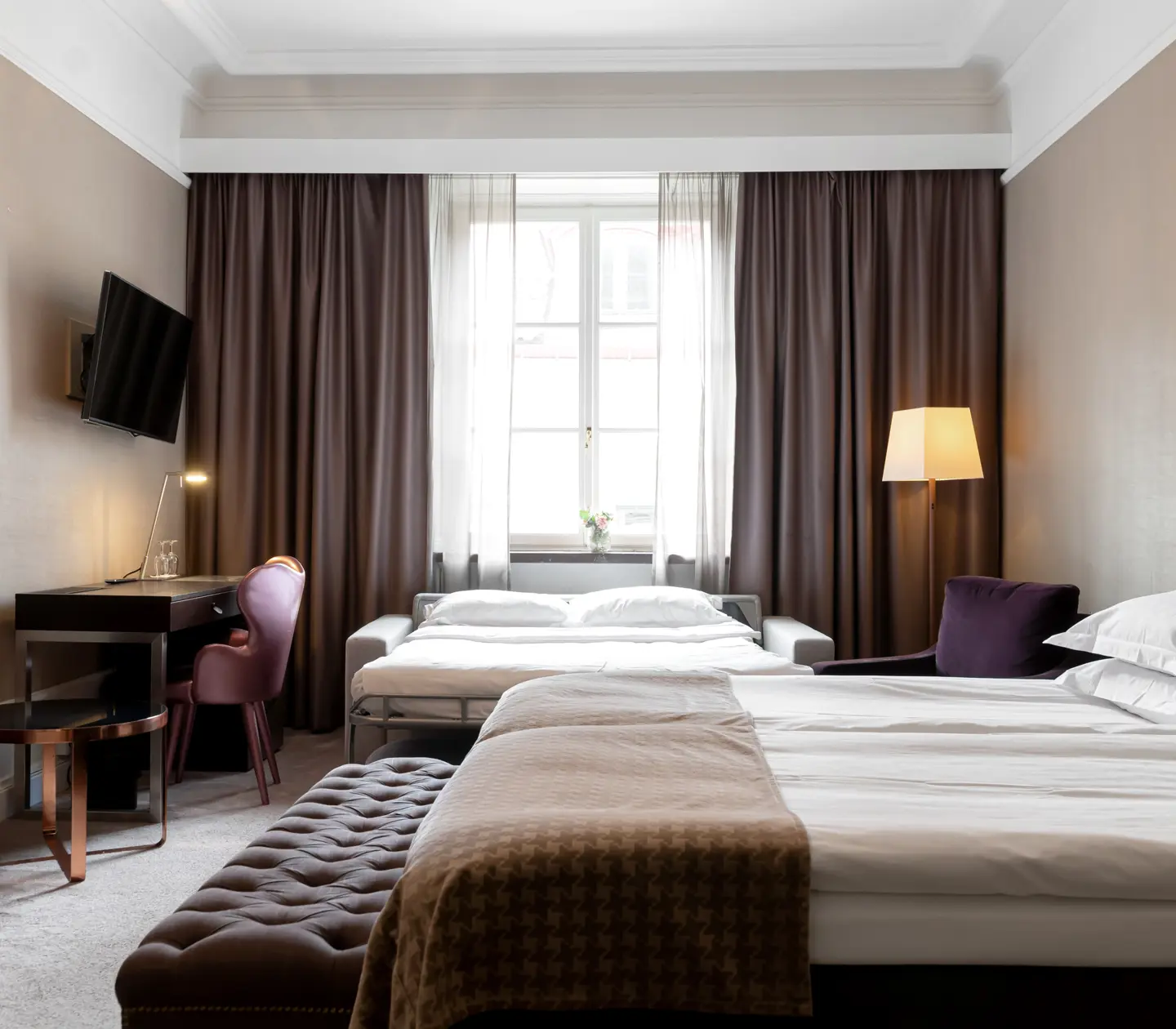Hotel room with bed, sofa bed and desk