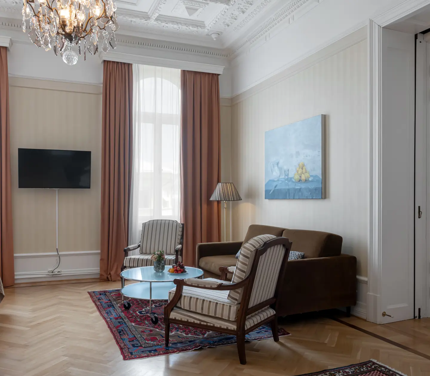 Charming hotel room with large windows, sofa area and TV