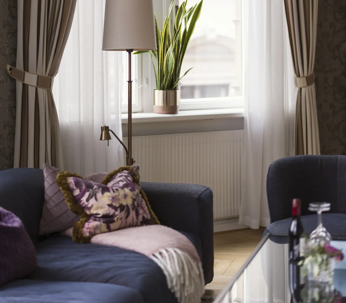 Close-up photo from a cozy suite with a sofa and window.
