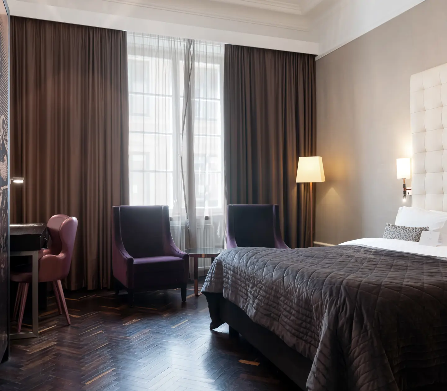 Bright suite with bed, large headboard and armchairs