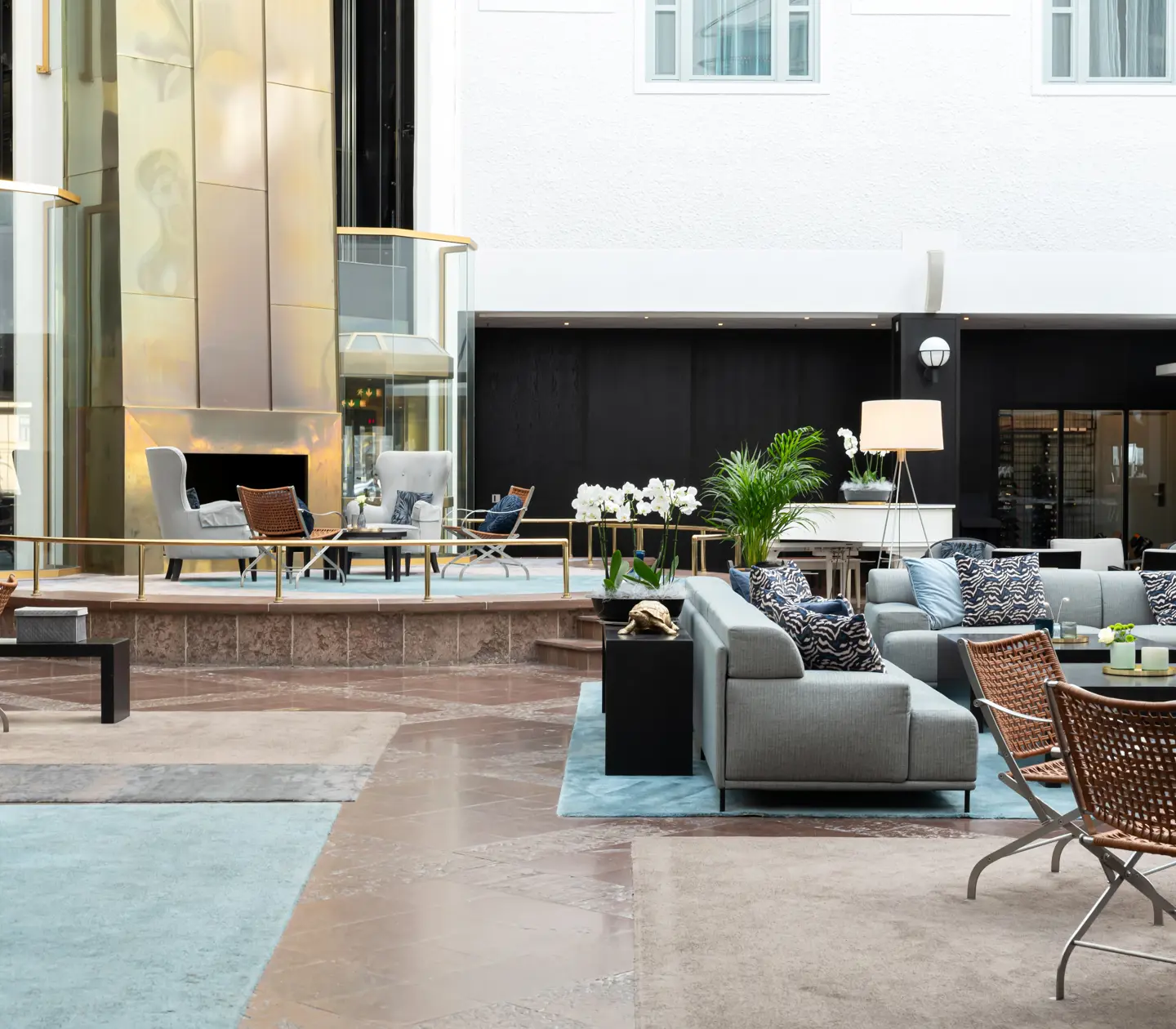 Bright hotel lobby with sofa groups and plants
