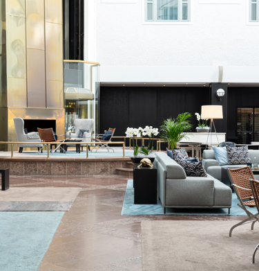Bright hotel lobby with sofa groups and plants