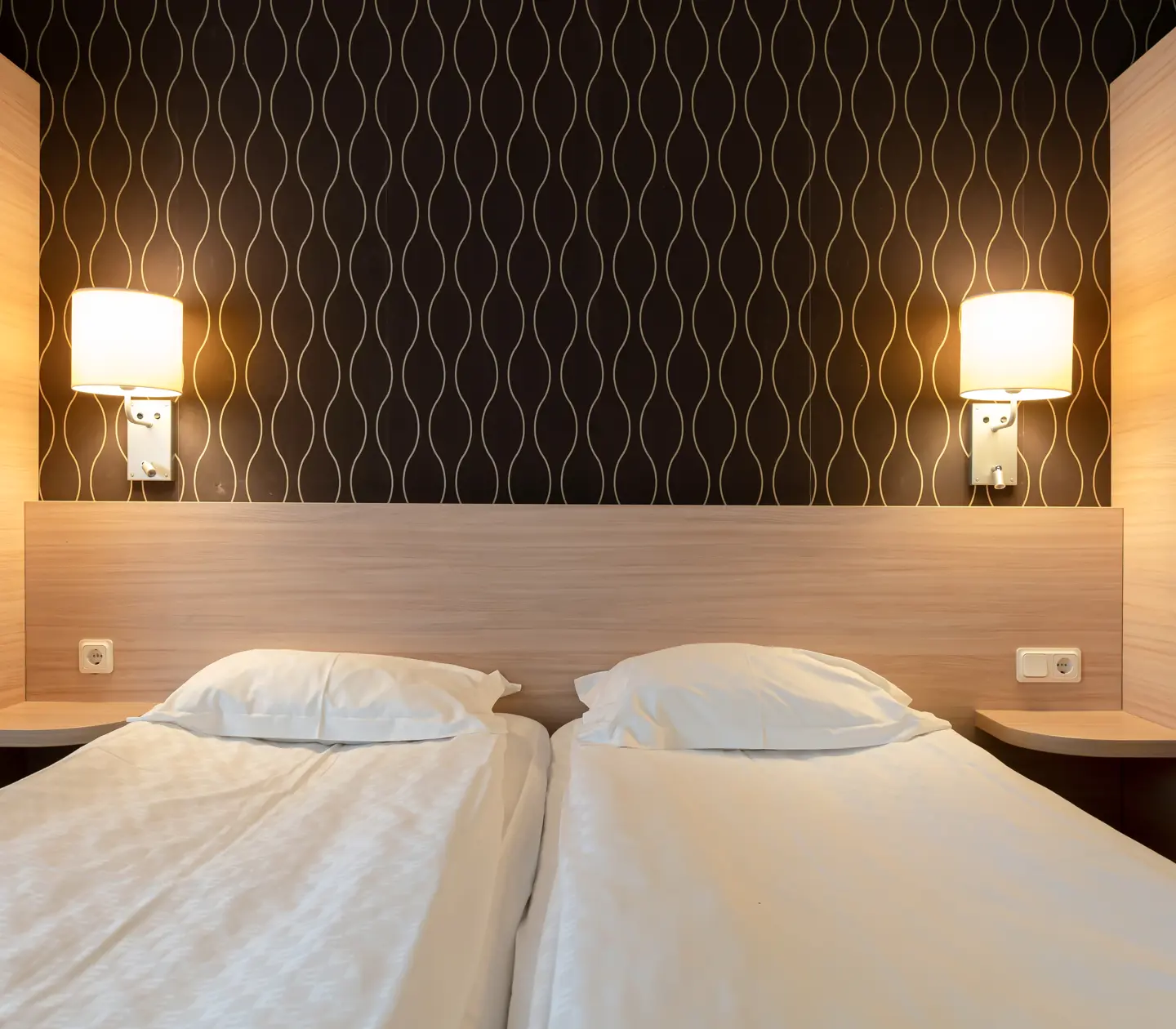 Cozy hotel room with bed, wardrobes and bedside lamps