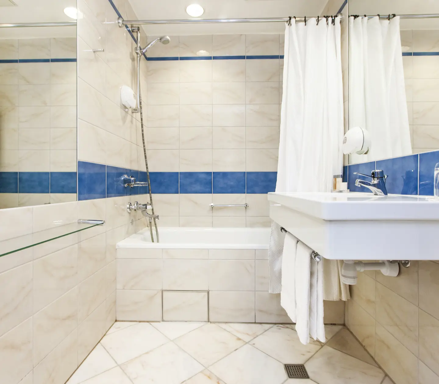 Beige bathroom with sink, mirror and bathtub