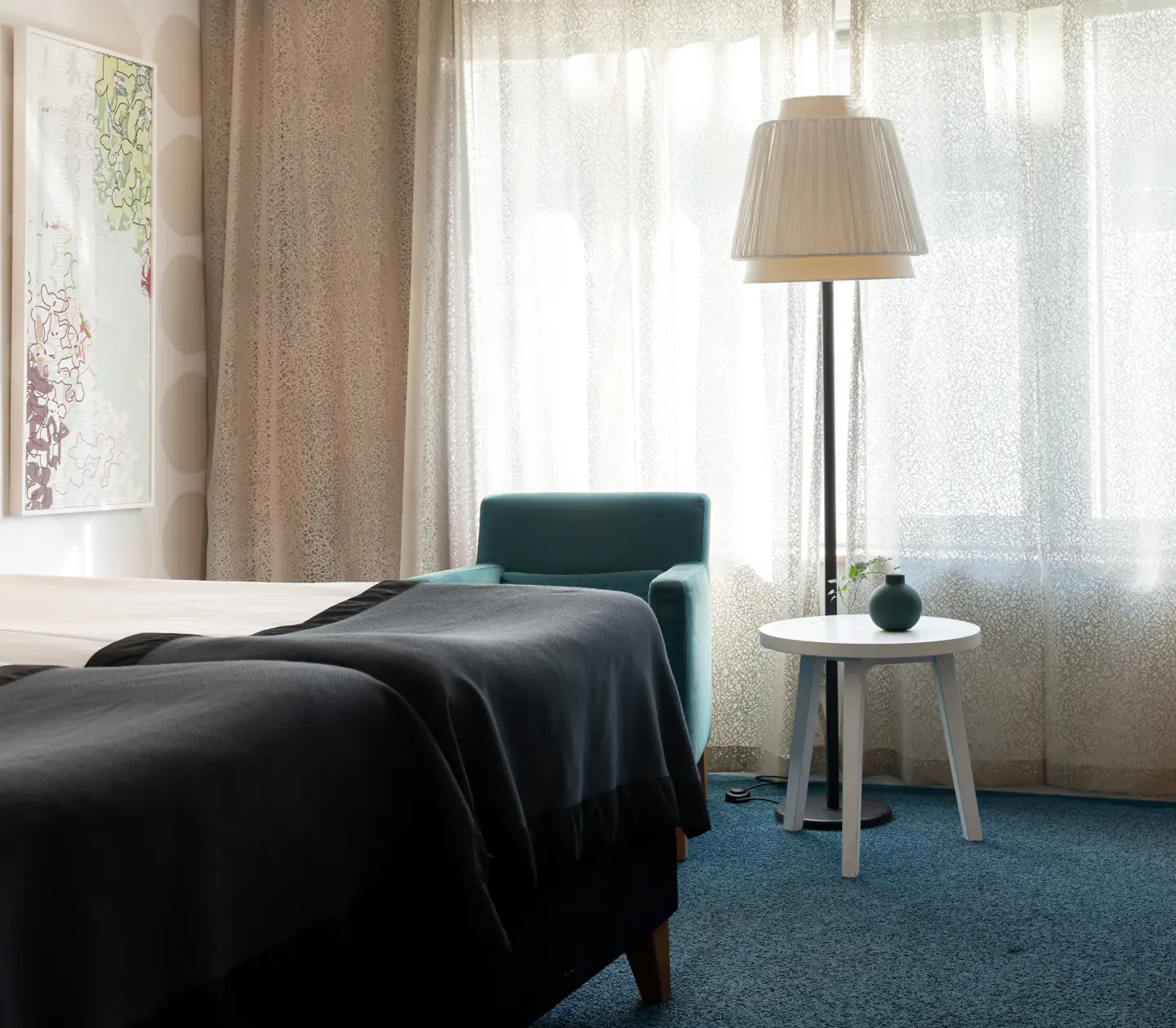 Cozy hotel room with bed, desk and armchair