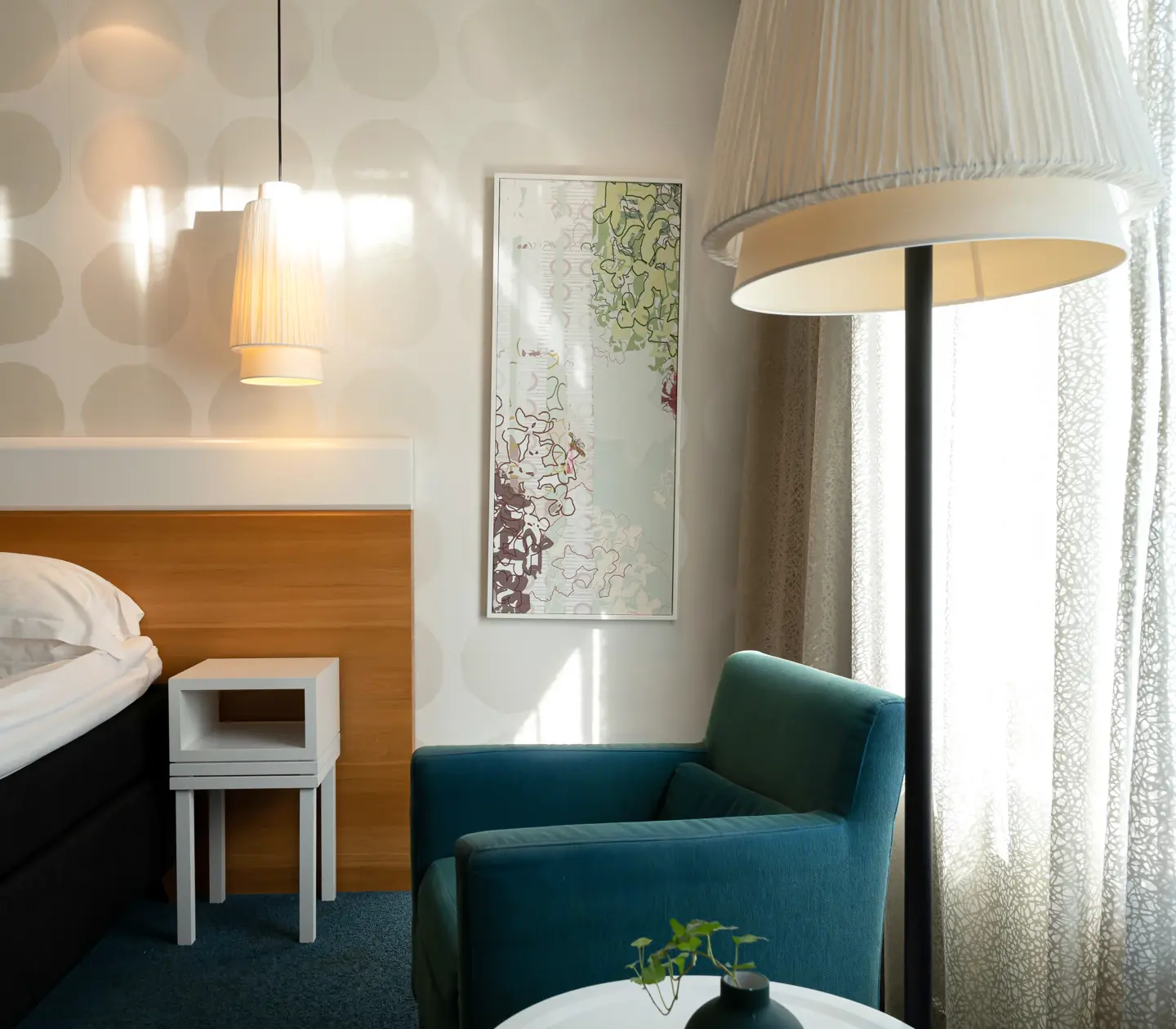 Cozy hotel room with bed, painting and armchair