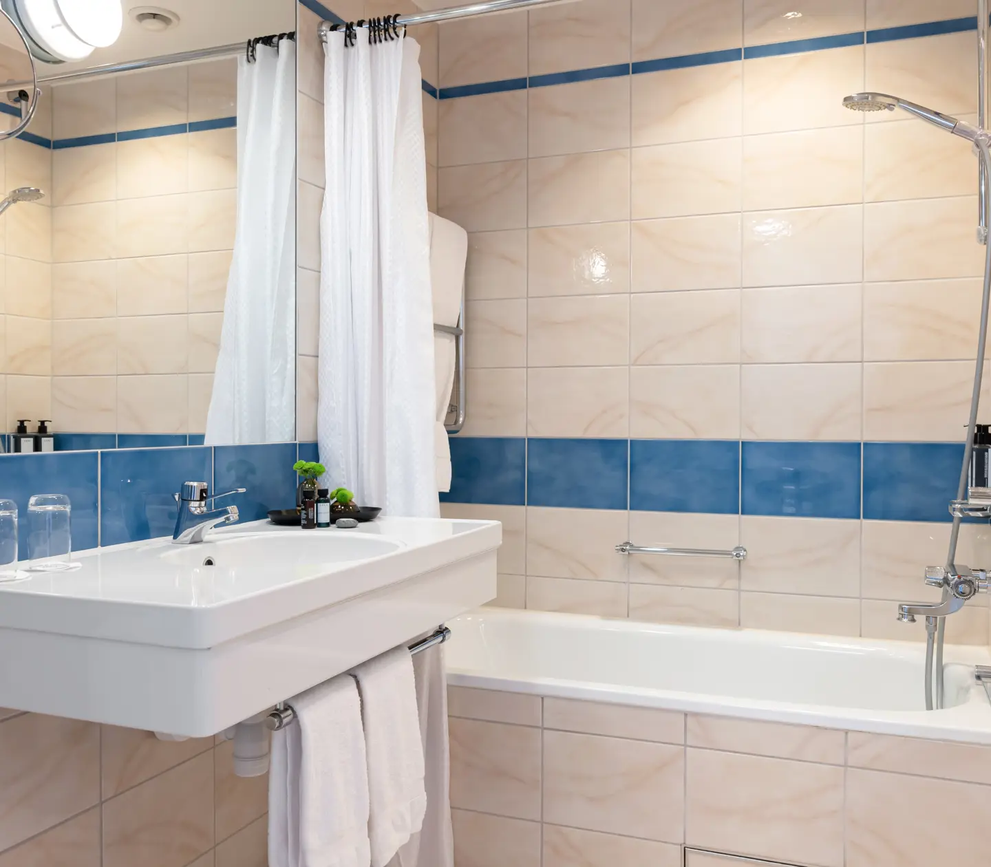 Beige bathroom with sink, mirror and bathtub
