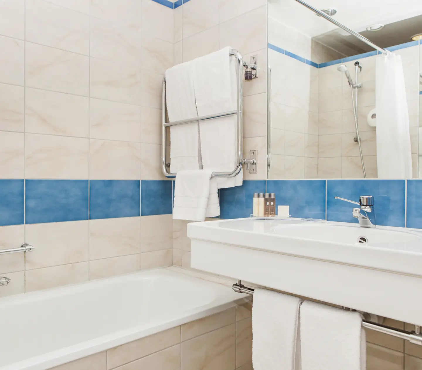 Beige bathroom with sink, mirror and bathtub
