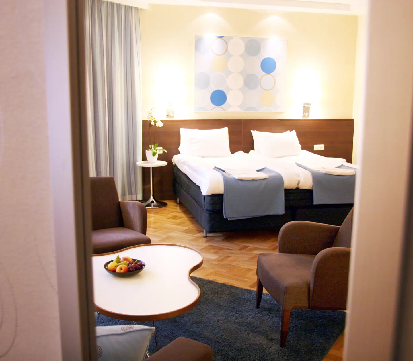 Bright hotel room with bed, armchairs and blackboard