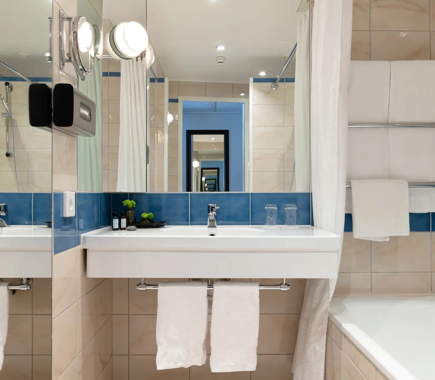 Beige bathroom with sink, mirror and bathtub