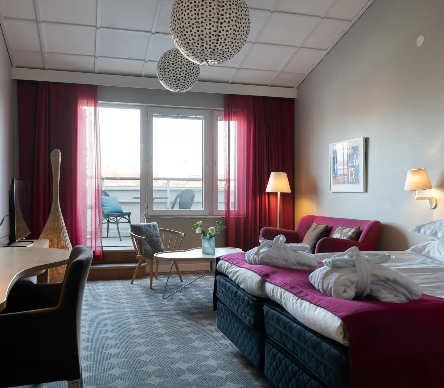 Cozy hotel suite with sofa, TV and balcony