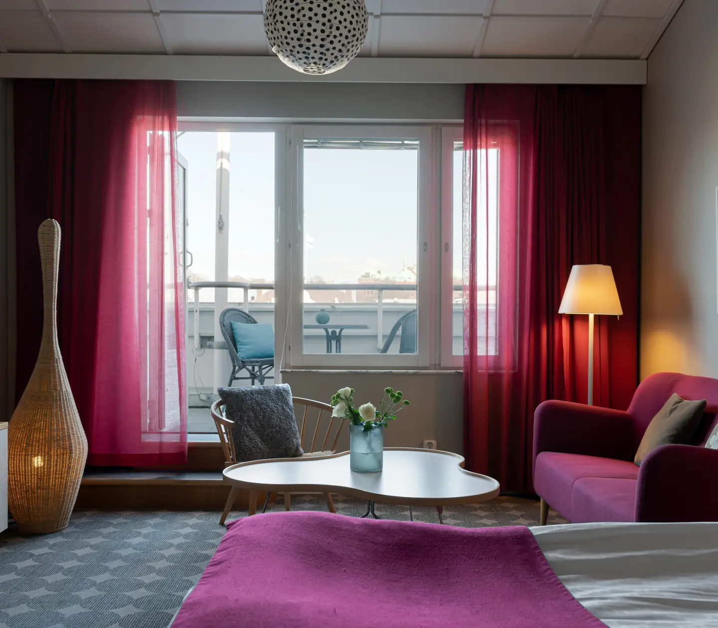 Cozy hotel suite with sofa, bed and dark headboard