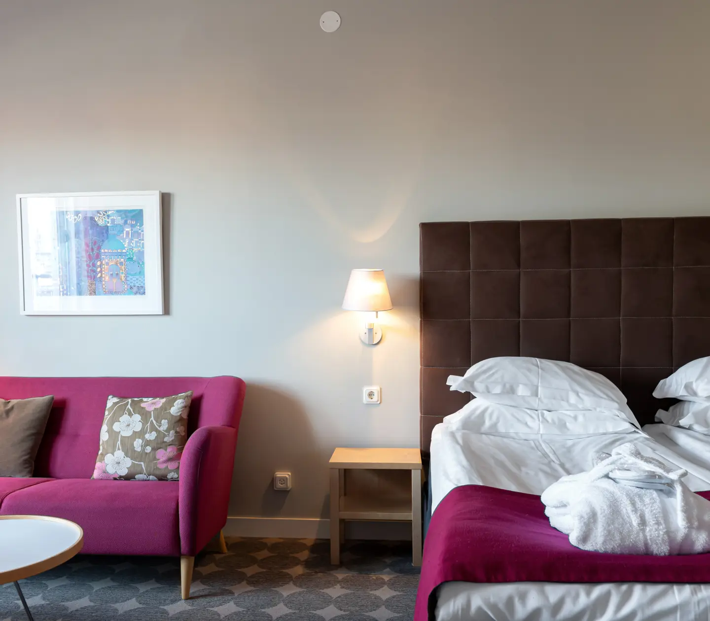 Cozy hotel suite with sofa, bed and balcony