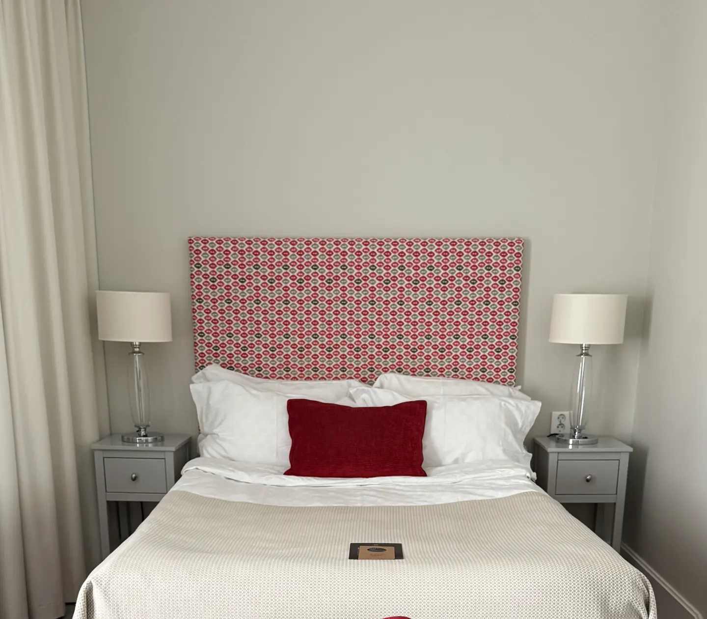 Hotel room with double bed, red headboard and desk