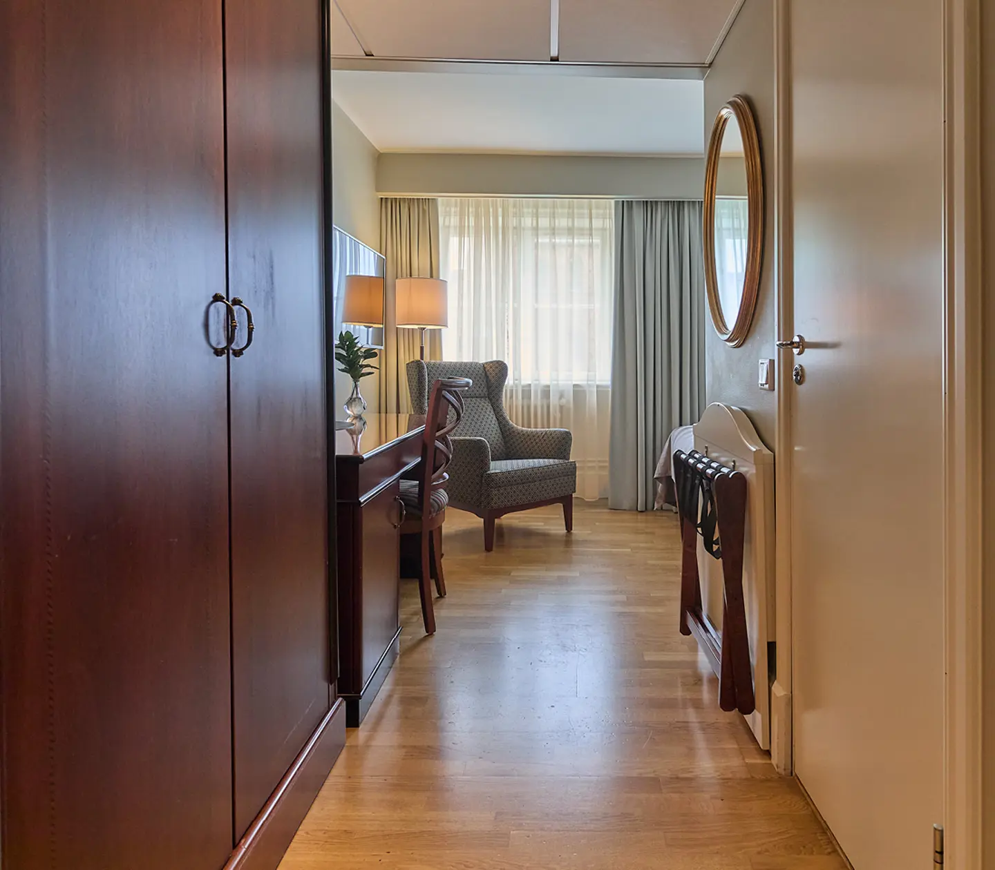 Hotel room with desk, armchair and TV