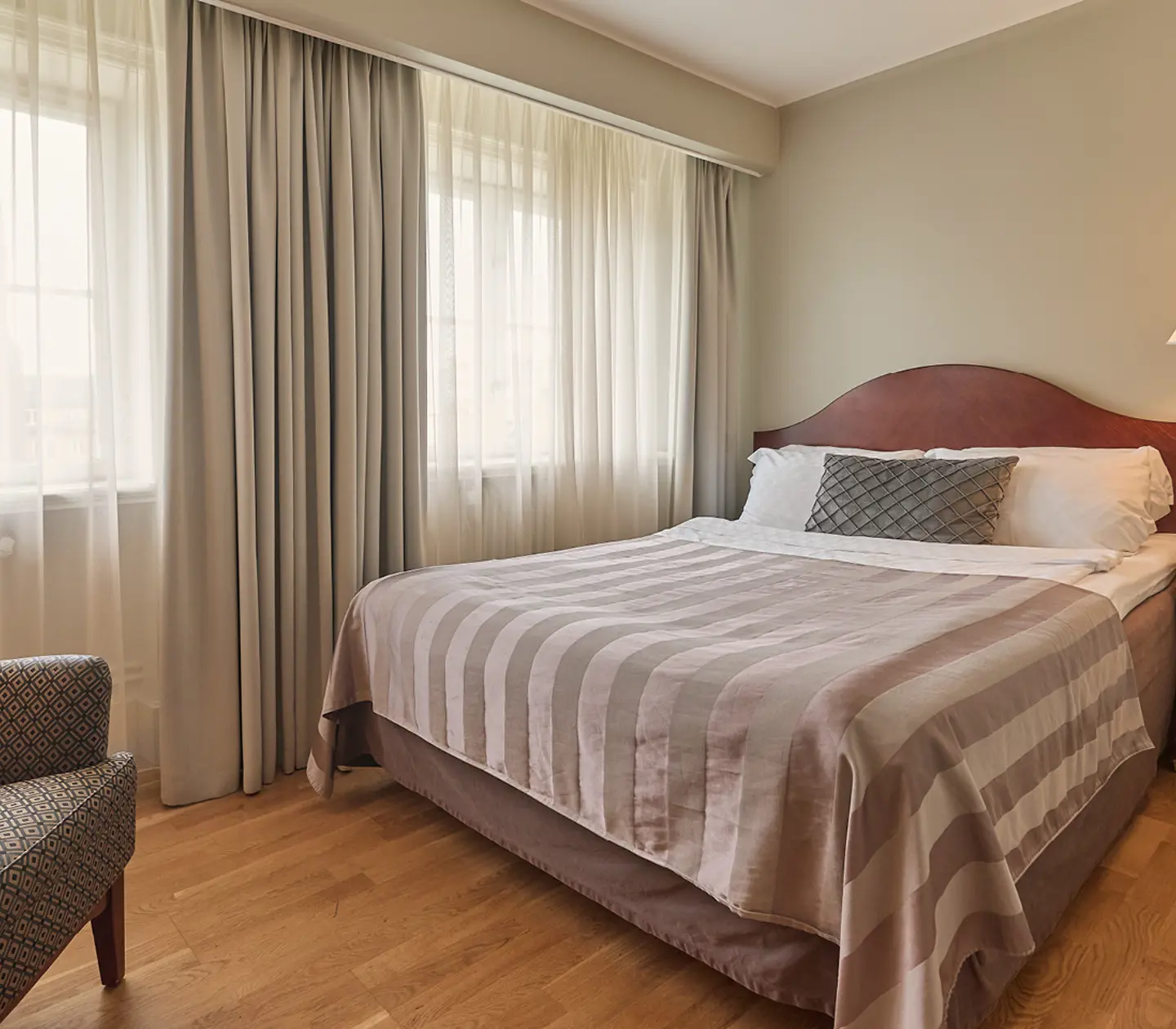 Hotel room with double bed, red headboard and desk