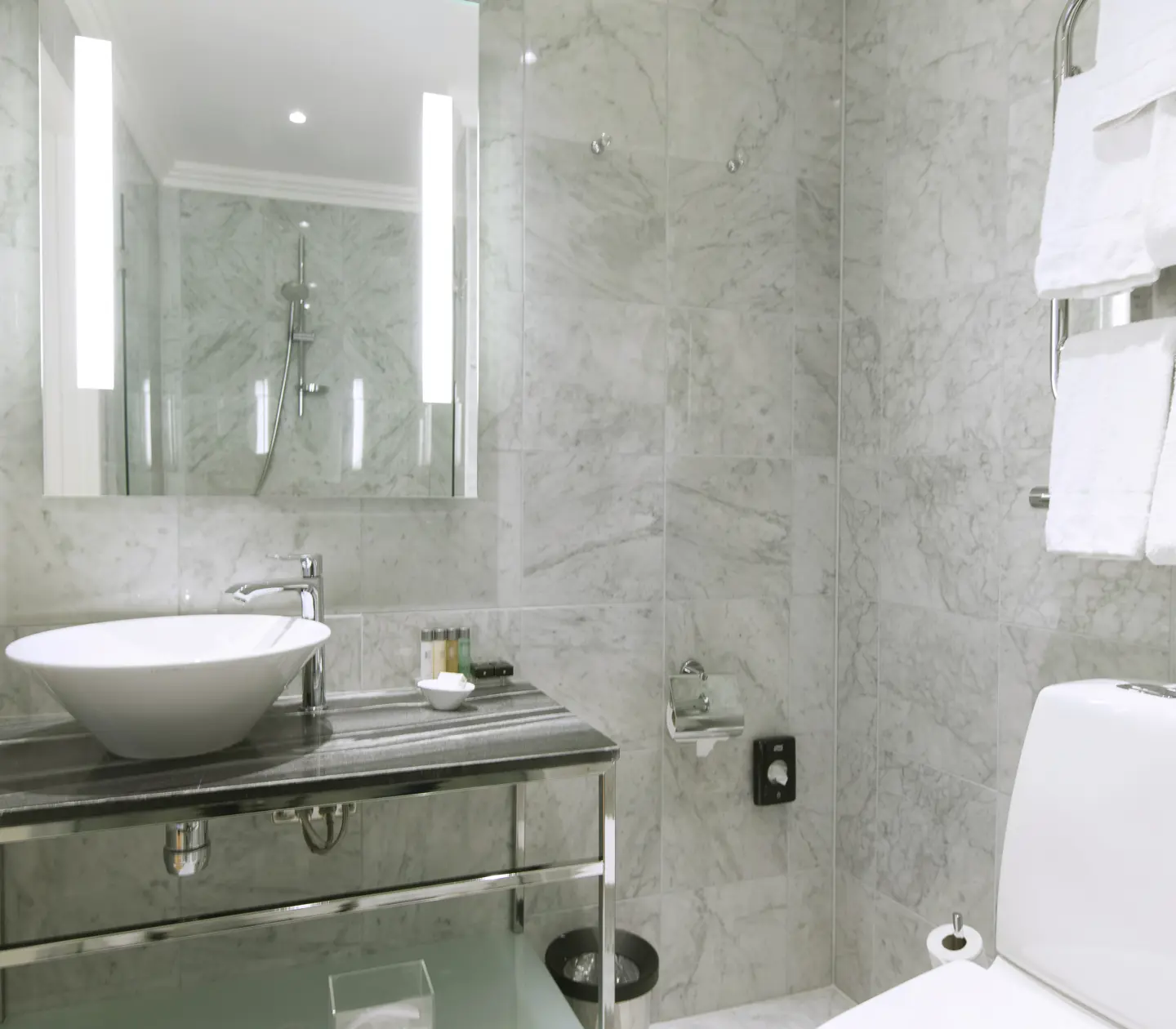Bright bathroom with sink, toilet and mirror