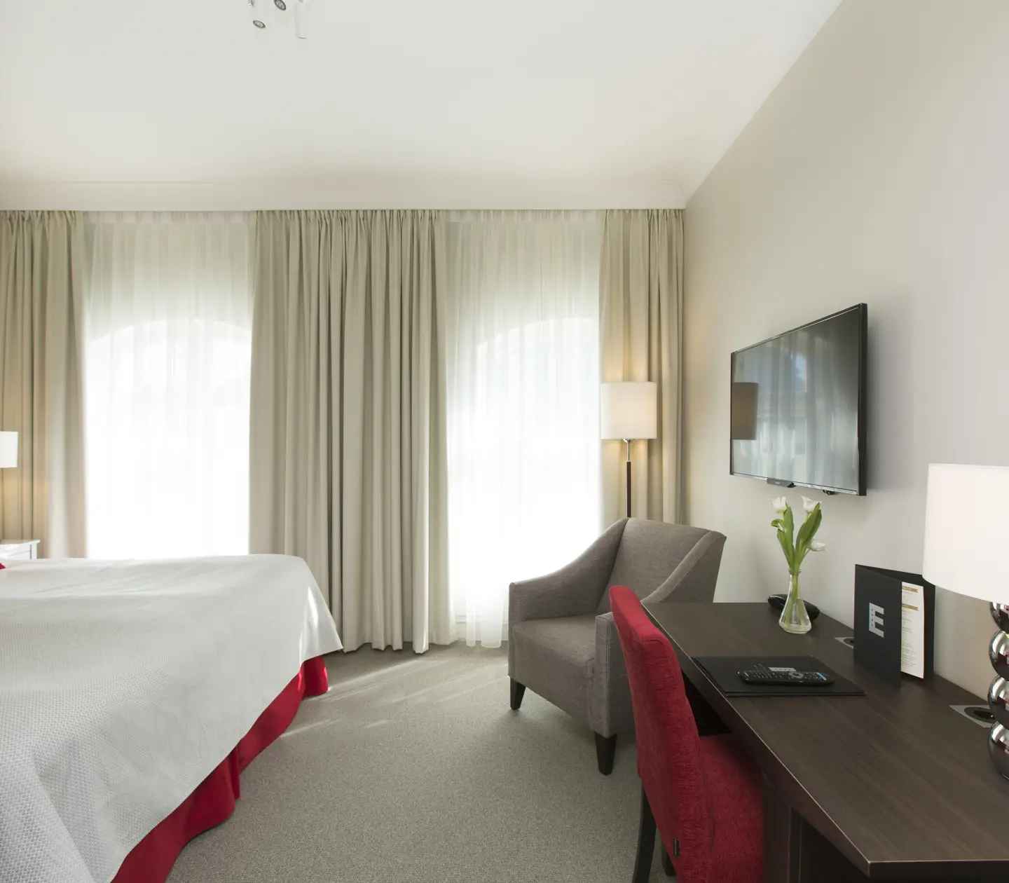 Hotel room with double bed, desk and armchair