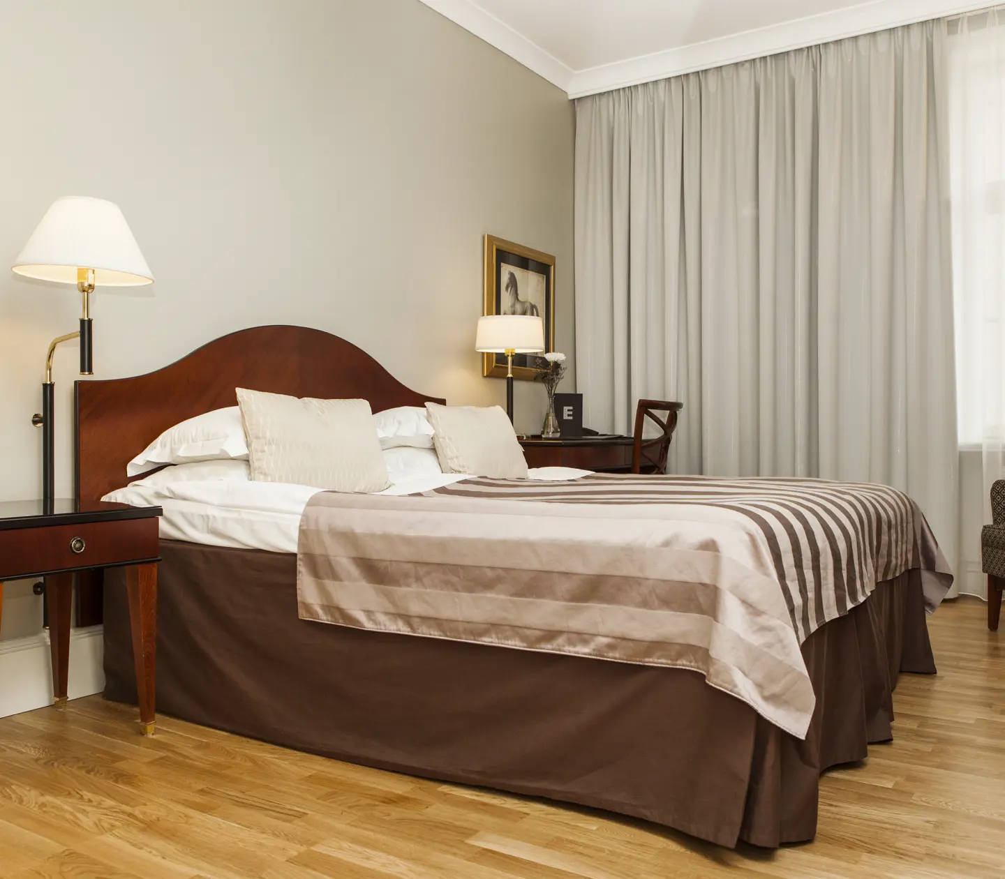 Hotel room with double bed, desk and curtains