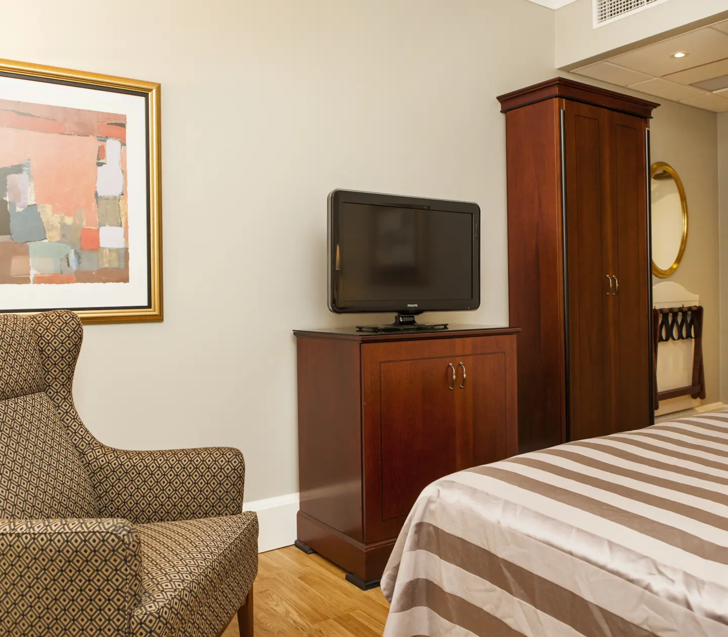 Hotel room with armchair, wardrobe and TV