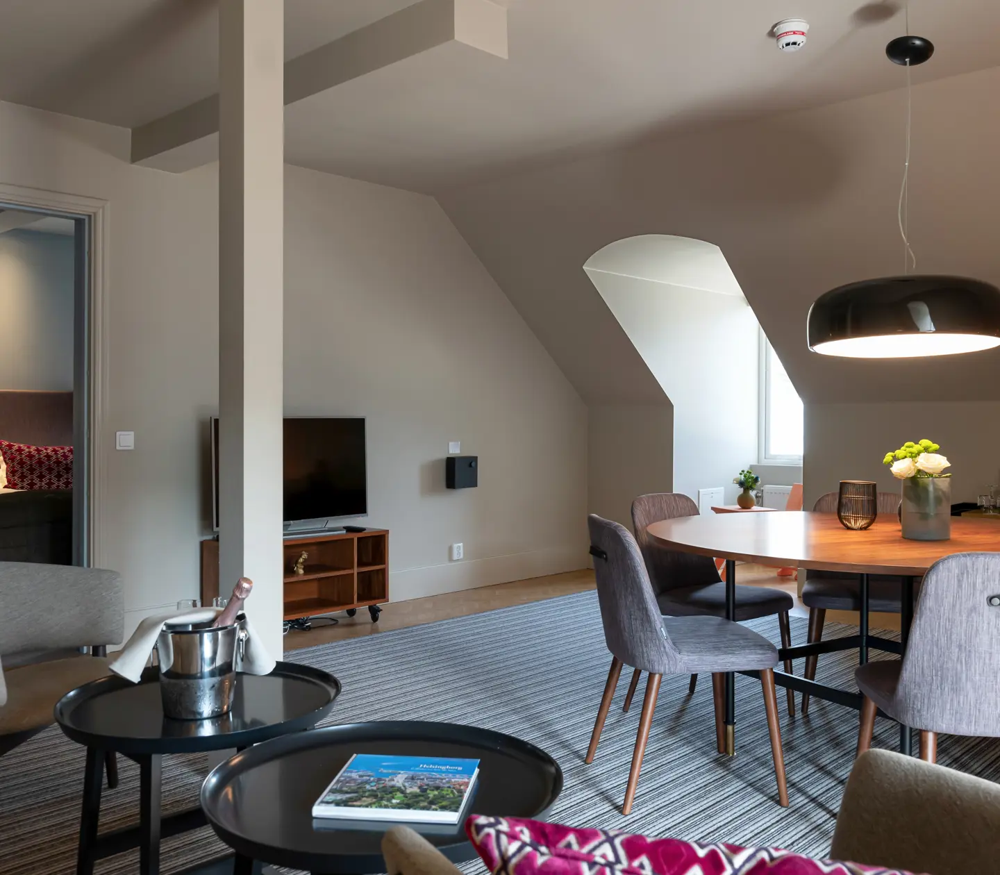 Suite with sitting area, dining table and door to bedroom