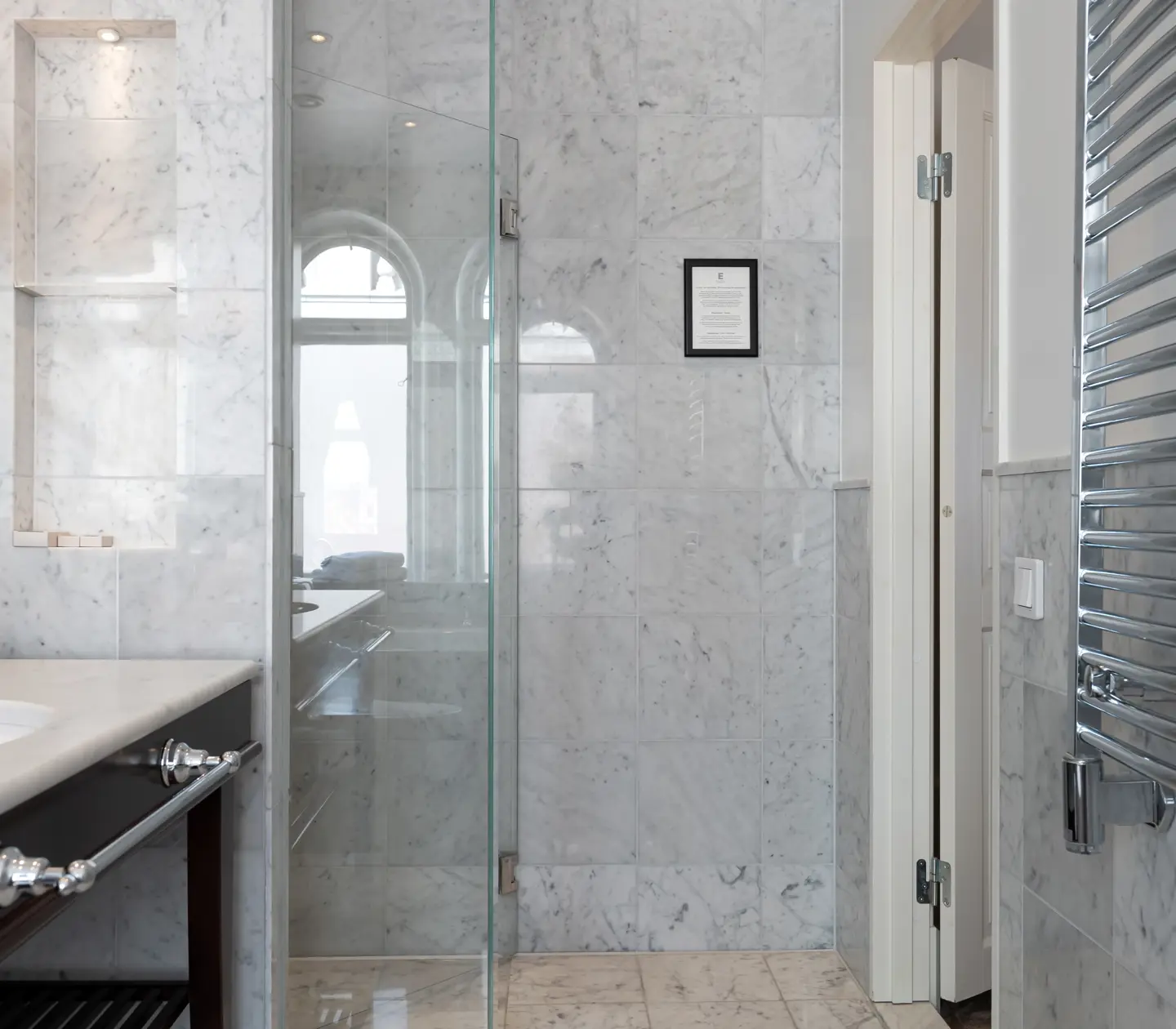 Bright bathroom with sink, mirror and heated towel rail
