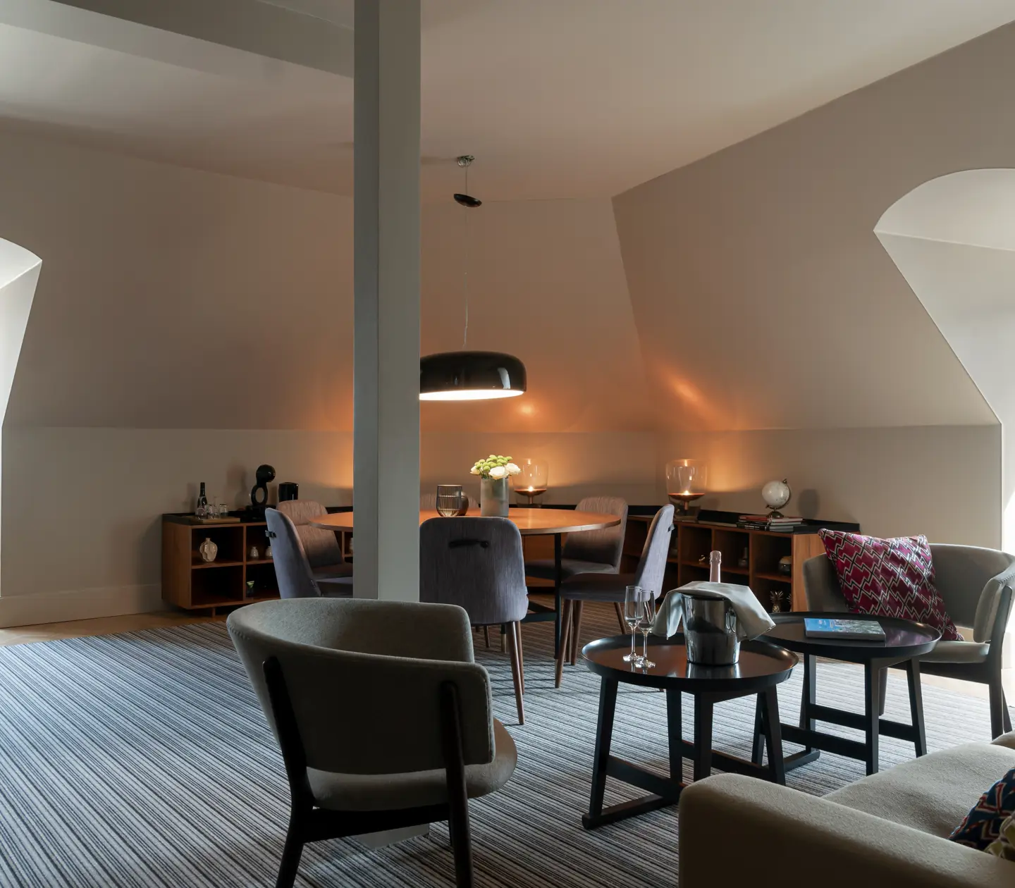 Suite with seating area, dining table and sloping walls