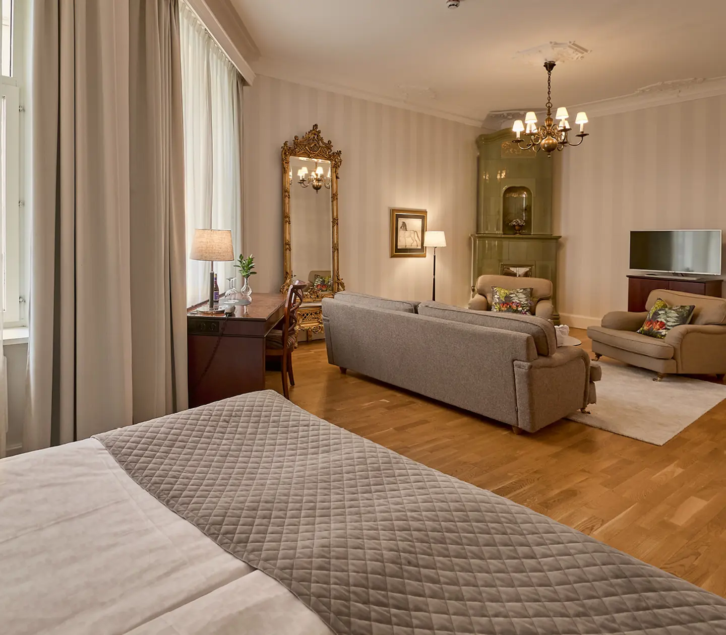 Suite with double bed, bedside table and curtains