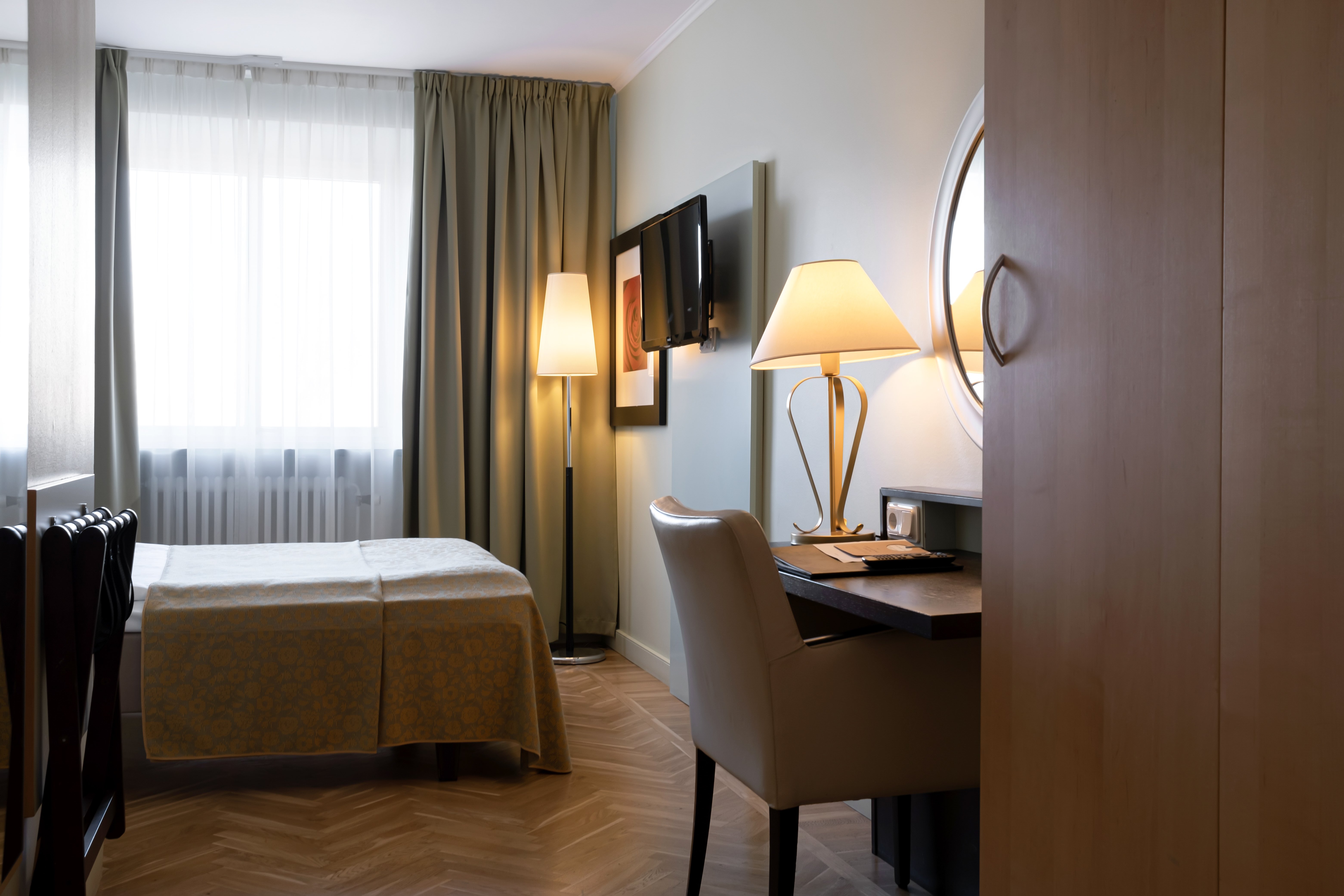 Hotellrum med säng, skrivbord och fönster