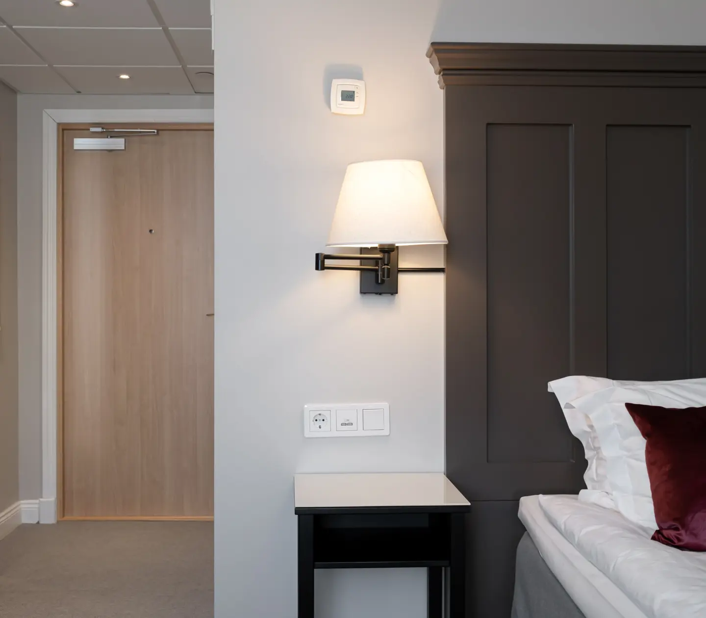 Hotel room with bed, bedside lamp and mirror