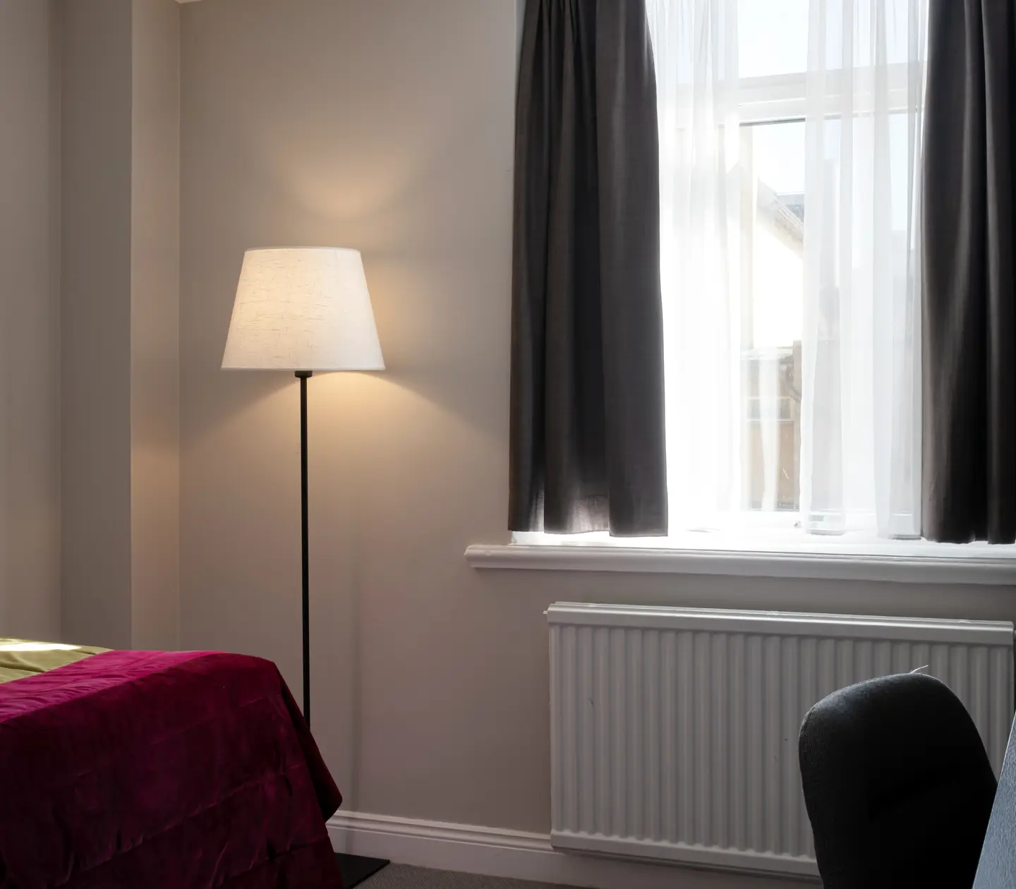 Hotel room with window, floor lamp and desk