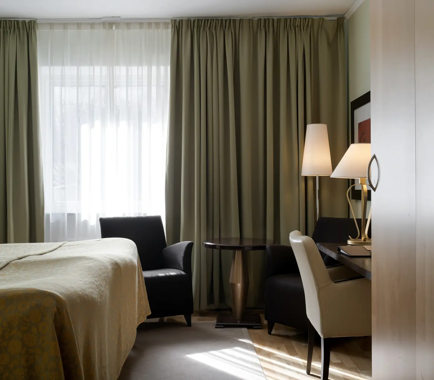 Hotel room with bed, armchairs and desk