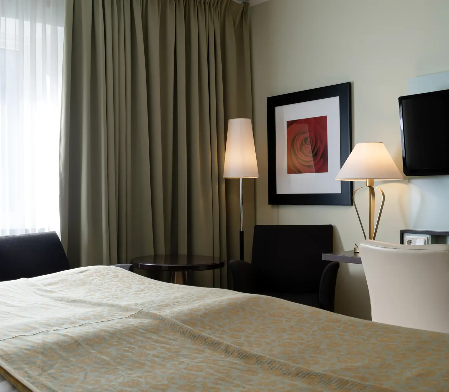 Hotel room with TV, armchairs and desk