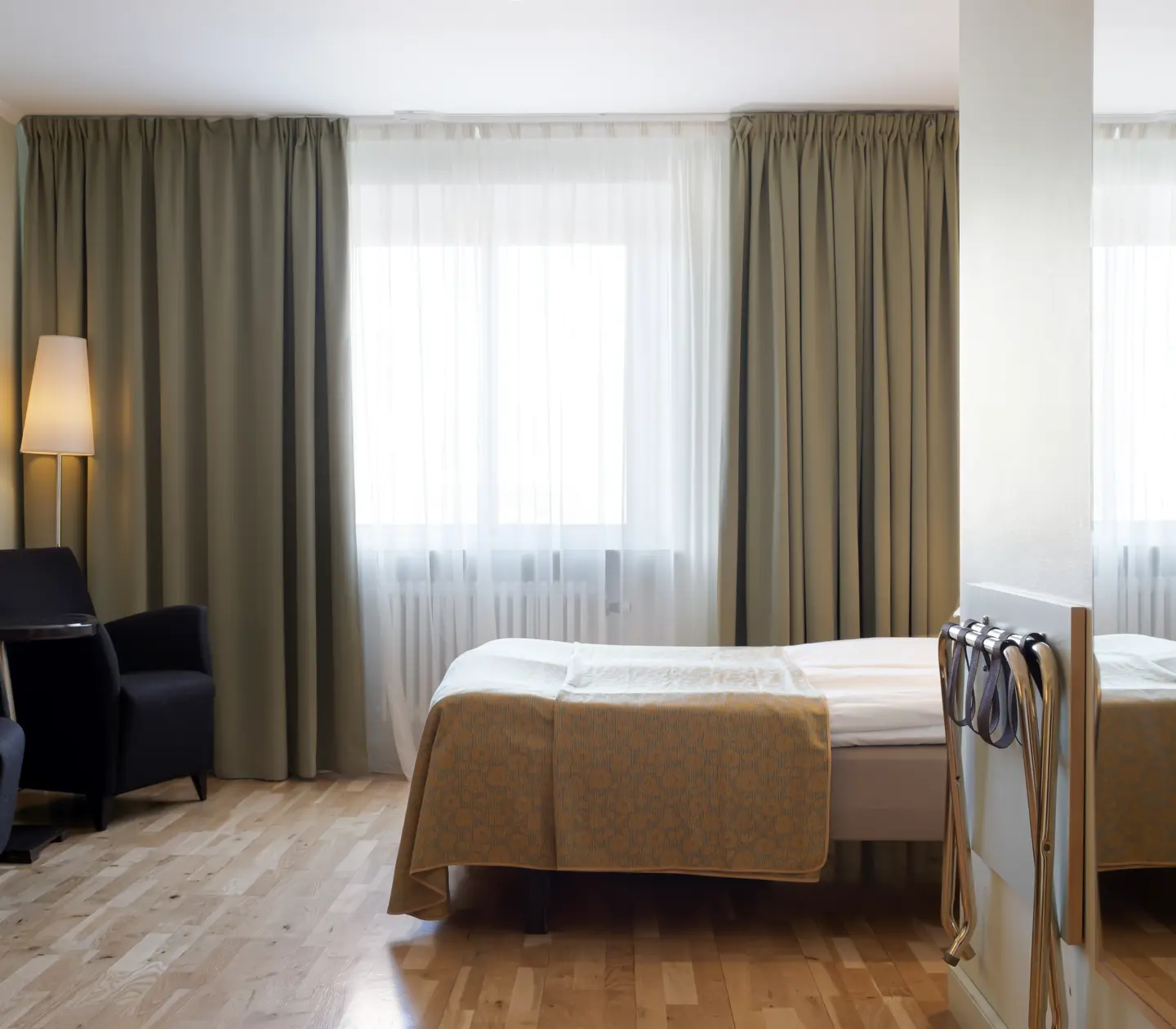 Hotel room with bed, armchairs and window