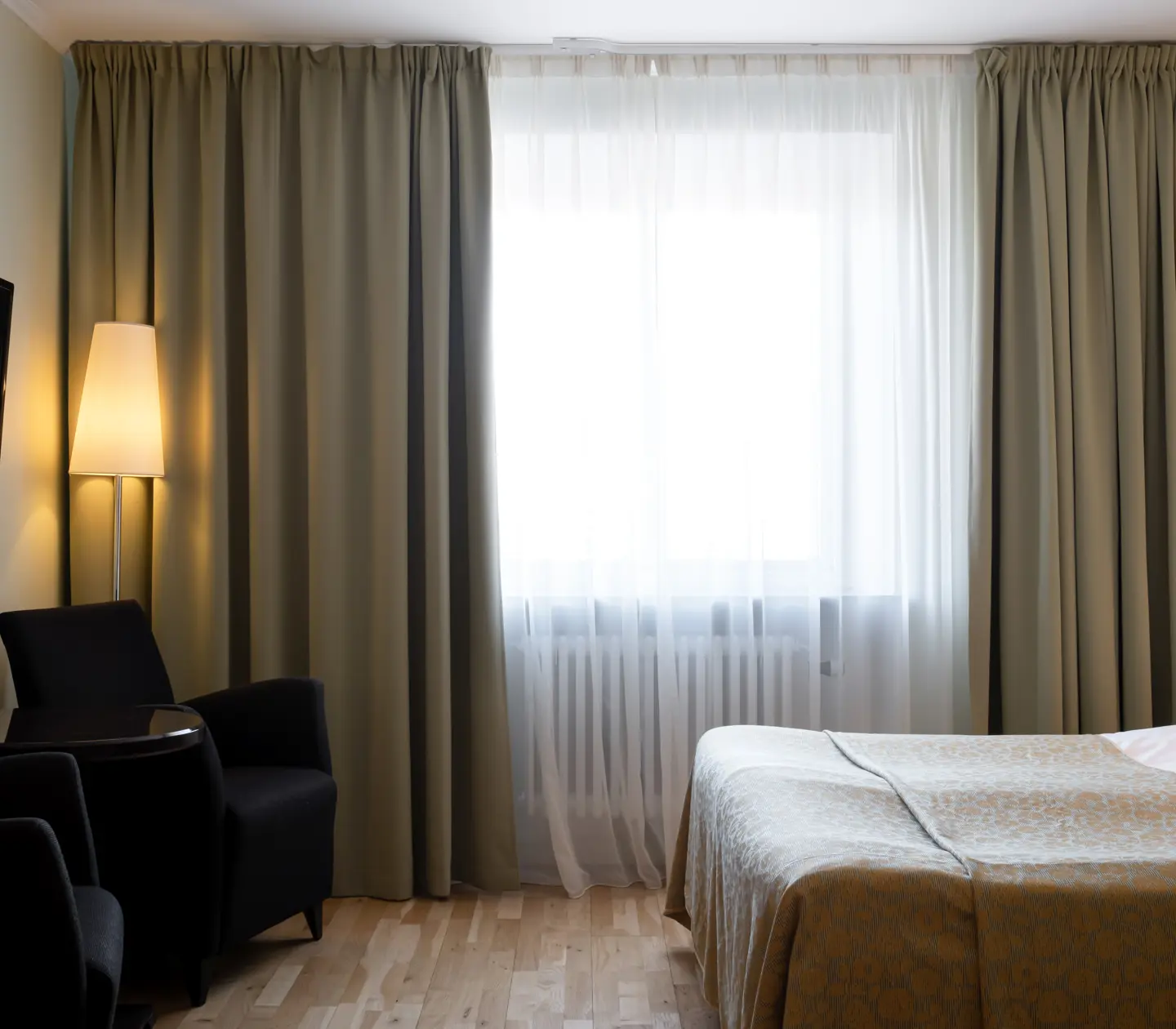 Hotel room with bed, armchairs and window