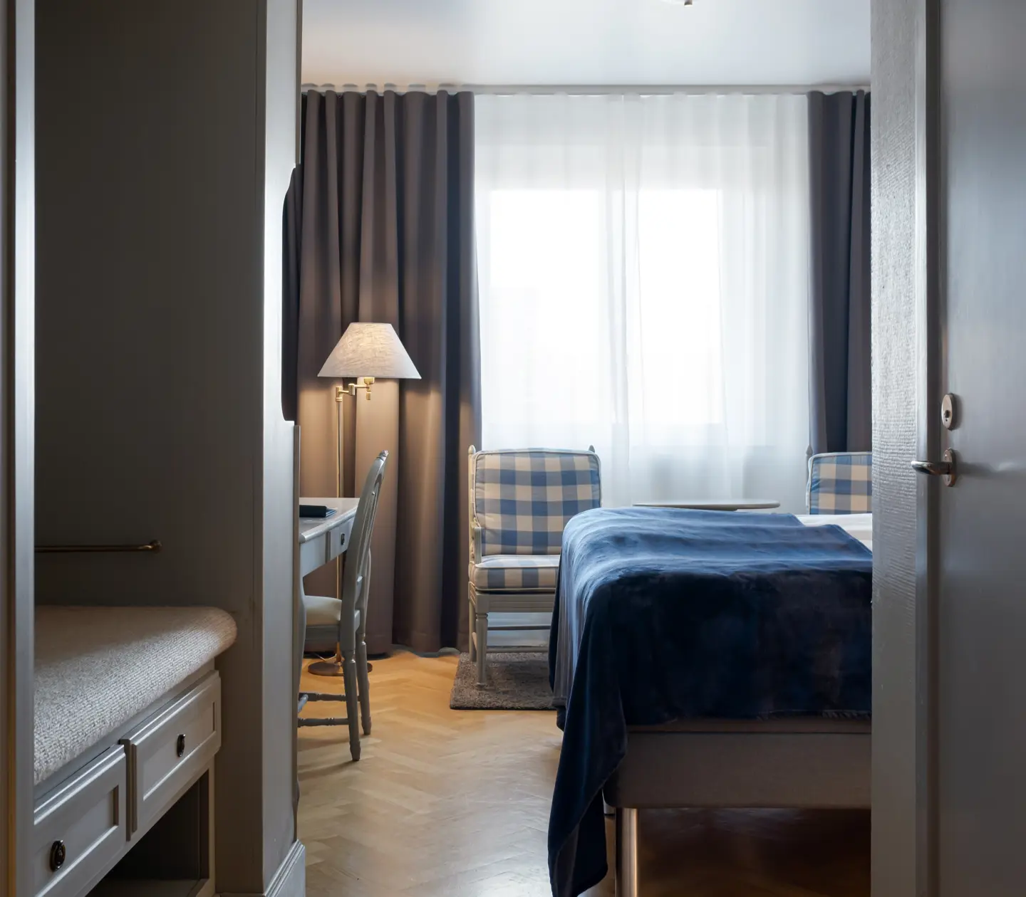 Hotel room with bed, armchairs and desk