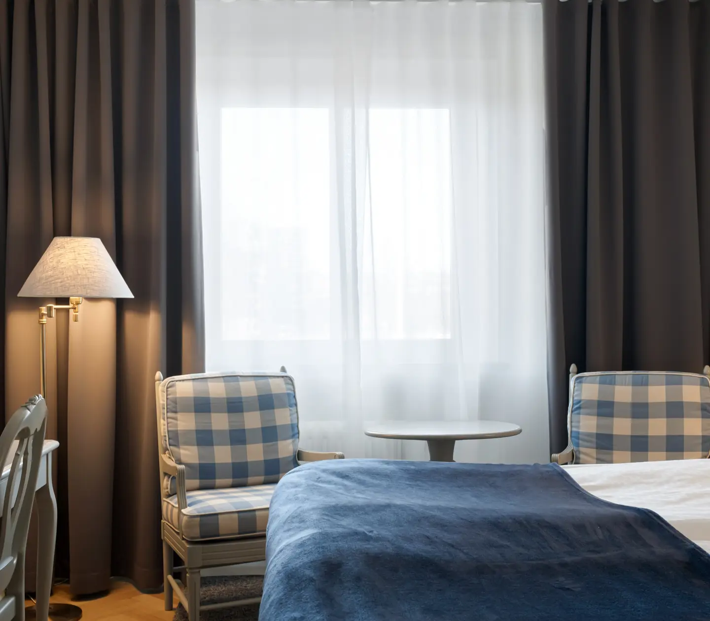 Hotel room with bed, armchairs and window