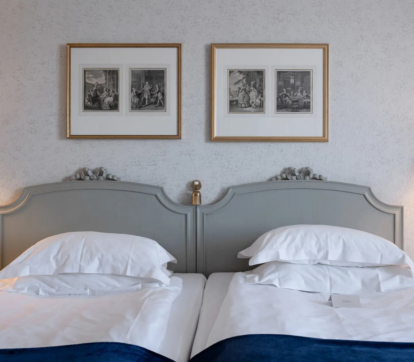 Hotel room with bed, bedside lamp and paintings