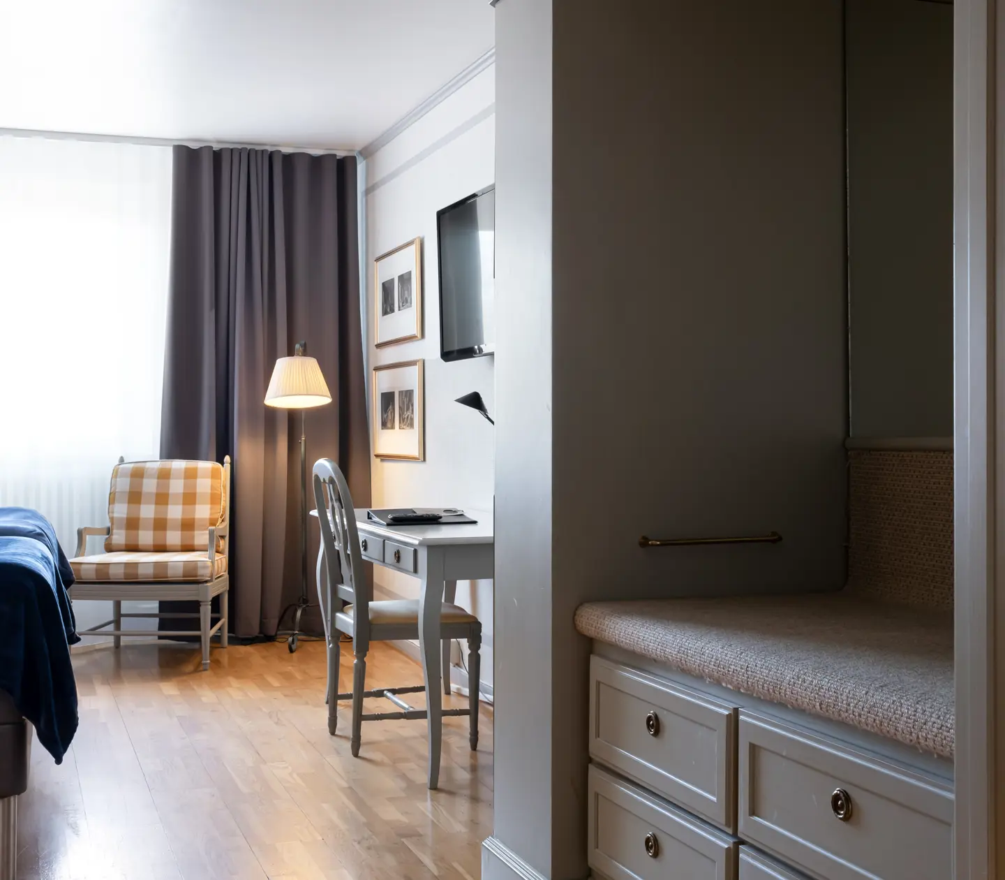 Hotel room with desk, armchairs and wardrobe