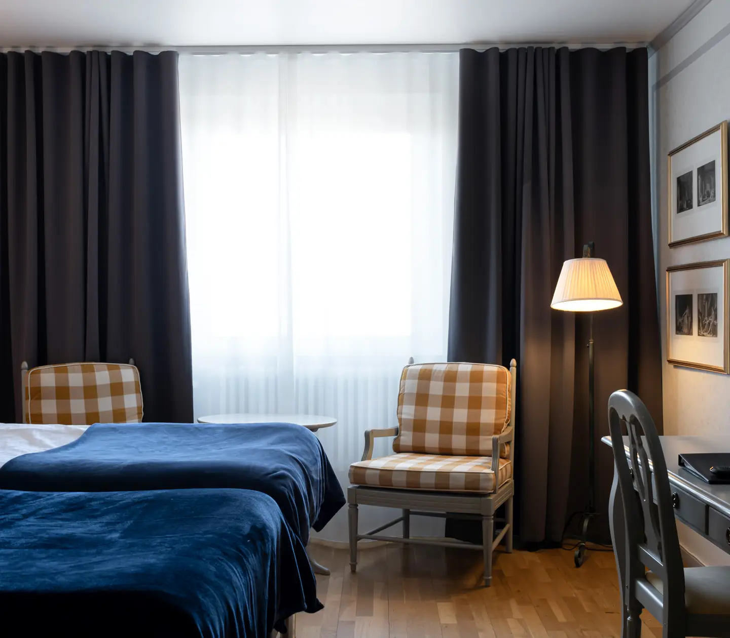 Hotel room with bed, armchairs and desk