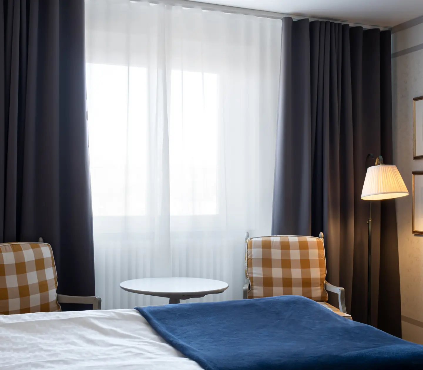 Hotel room with bed, armchairs and window