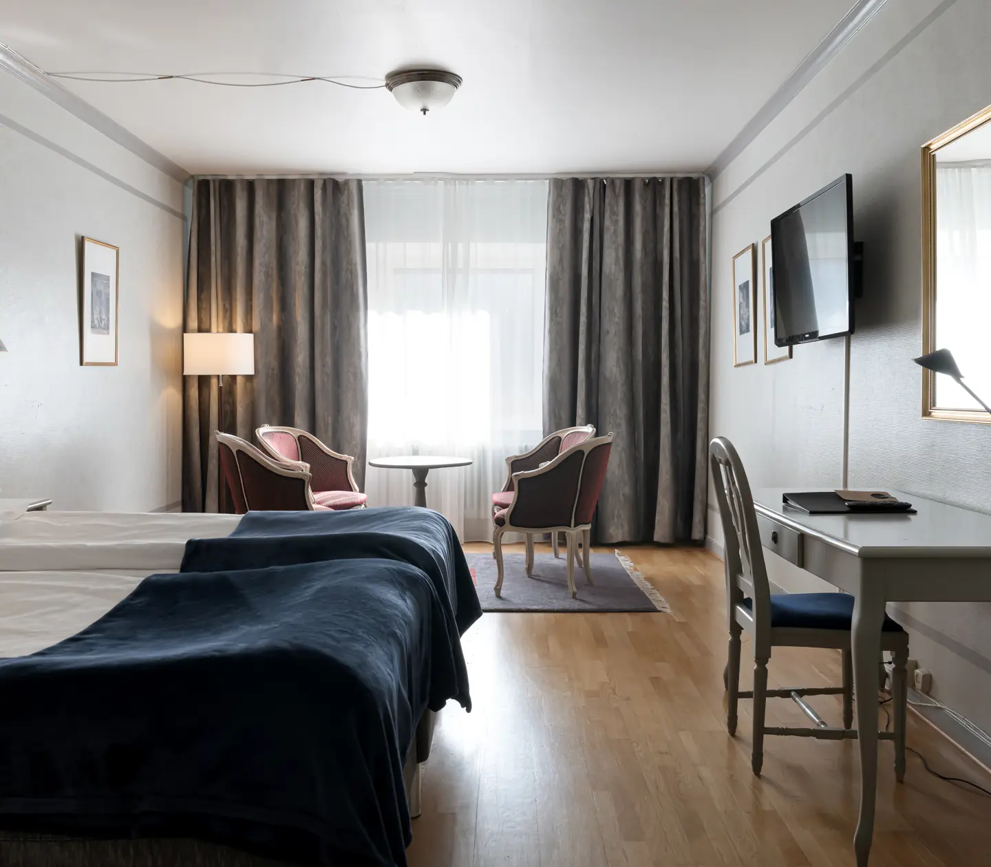 Hotel room with bed, sitting area and desk