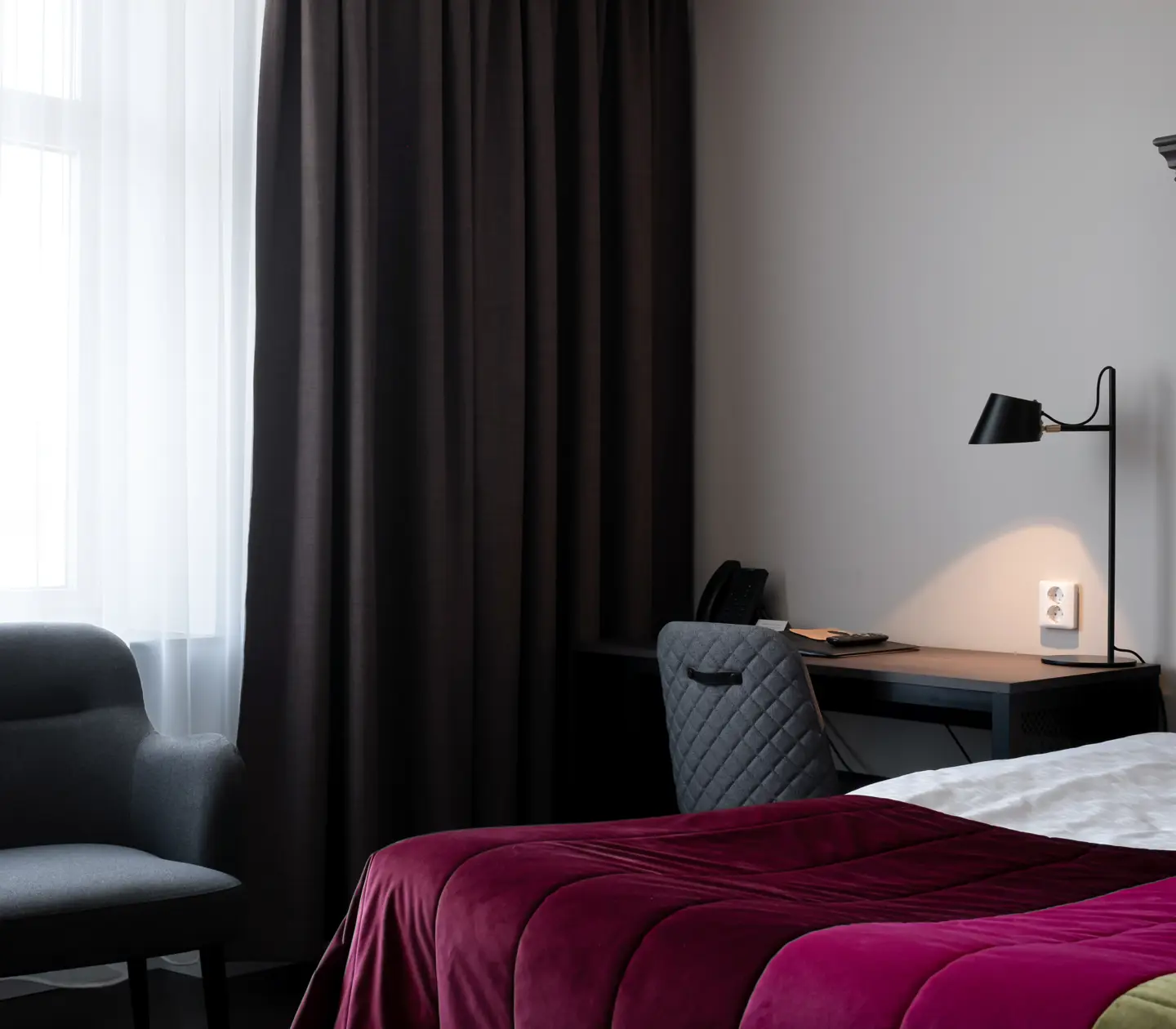 Hotel room with bed, large wooden headboard and desk