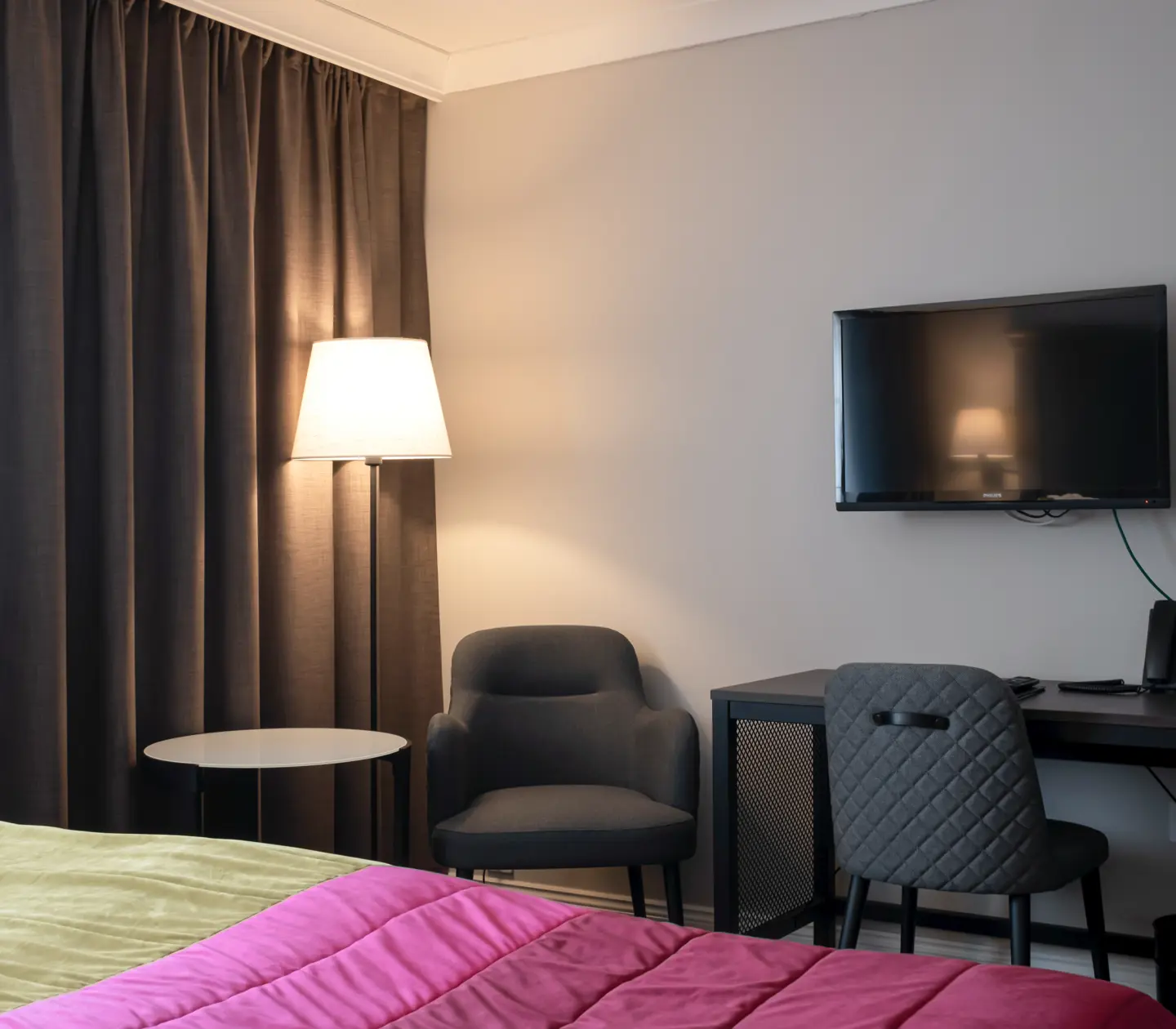 Hotel room with bed, desk and armchair